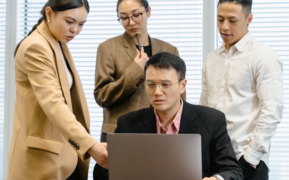 Un grupo de participantes de un taller revisa junto un notebook